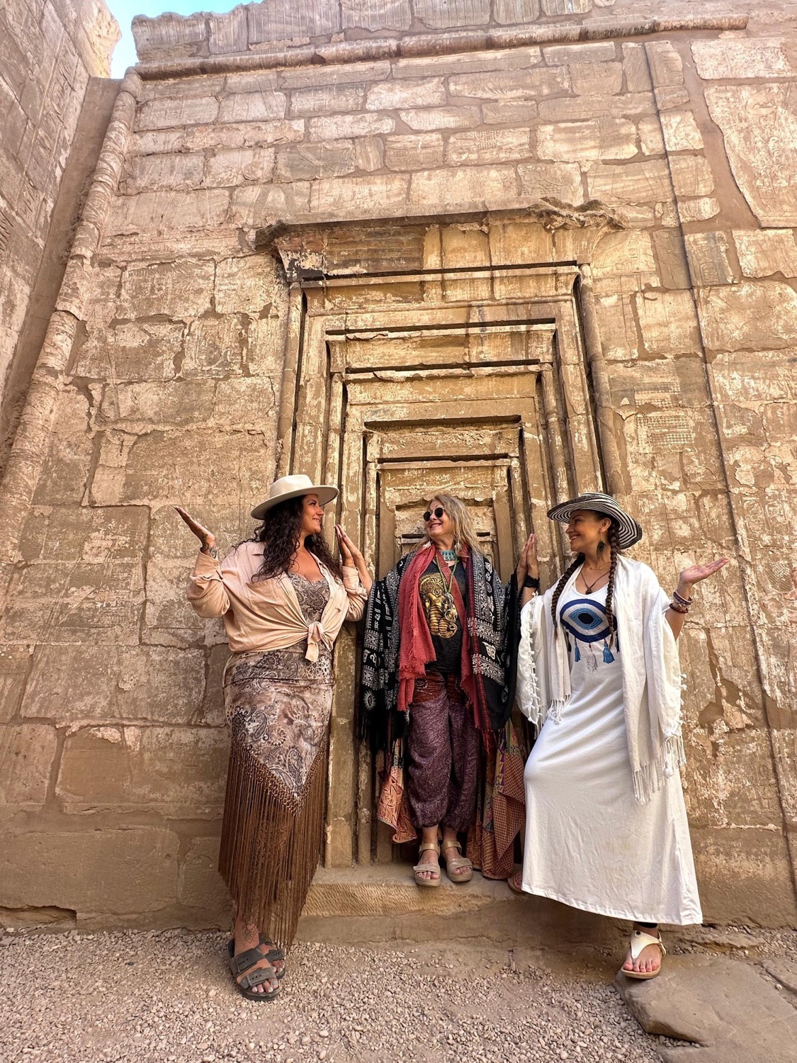 Three travellers standing together in the doorway of an Egyptian temple
